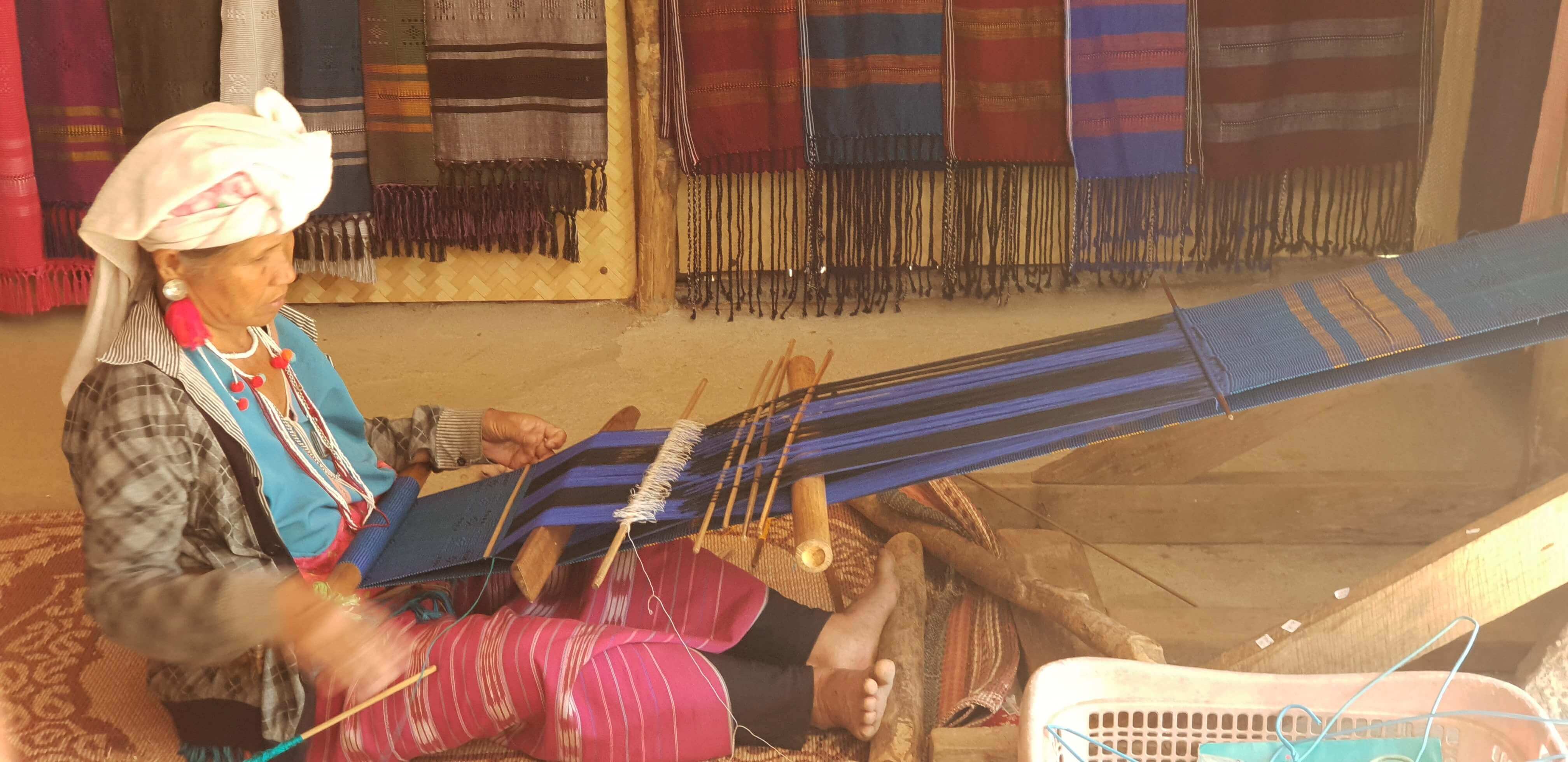An elderly woman making shawls in Mae Klang Luang village