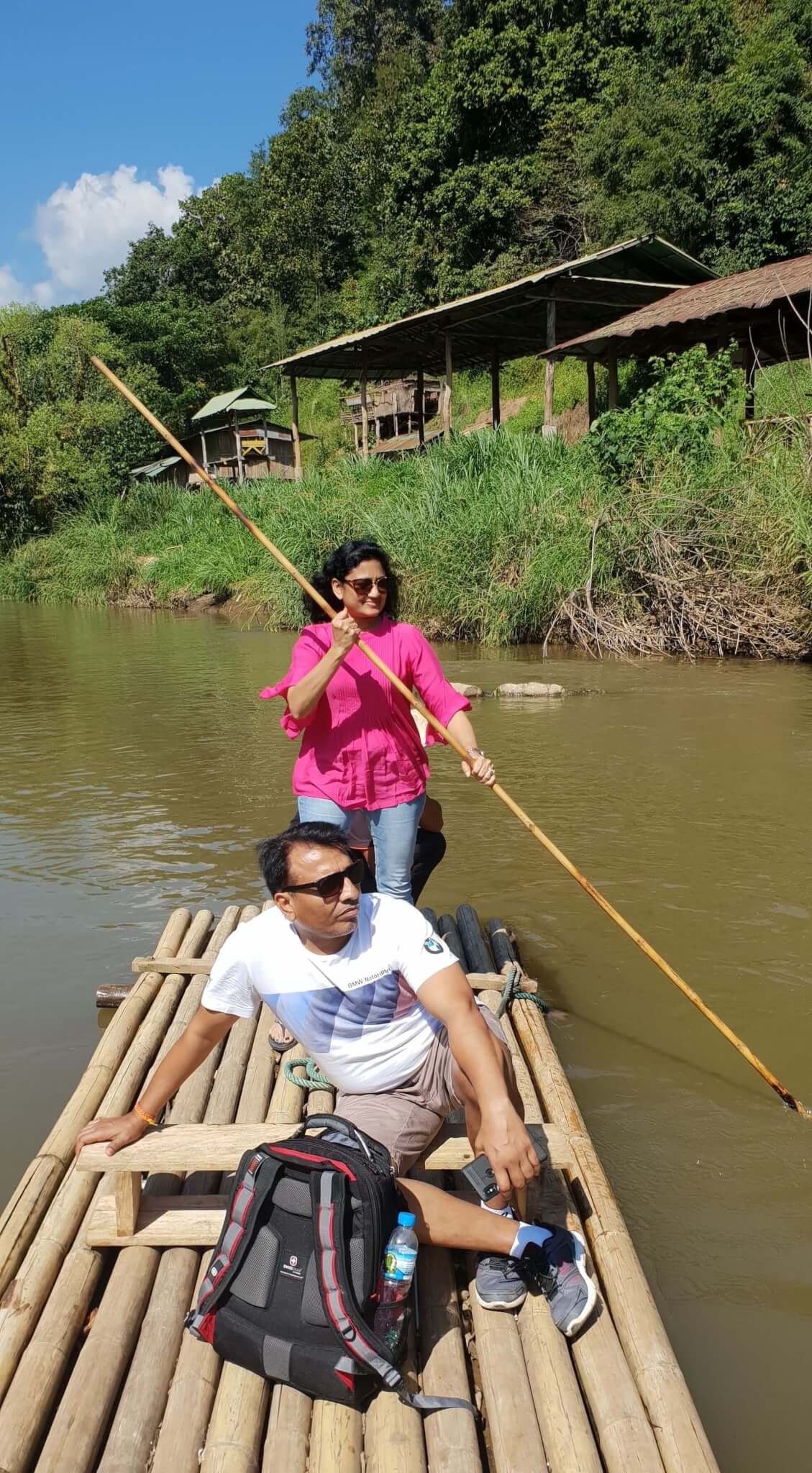 Mom guiding the bamboo raft herself as dad enjoys the views of the Mae Taeng river