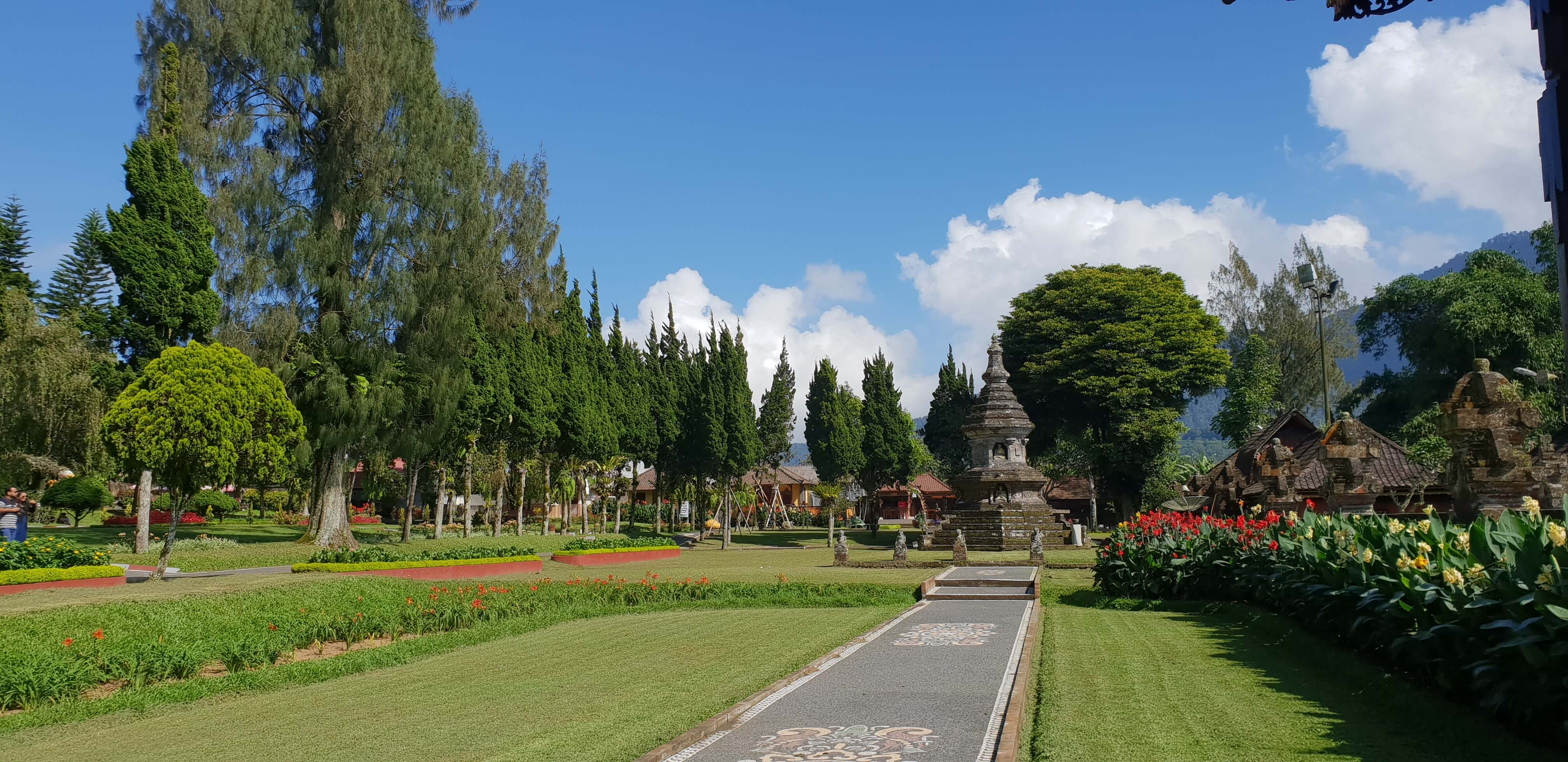 Lush green gardens leading to the Ulun Danu Beratan temple give it a scenic appeal