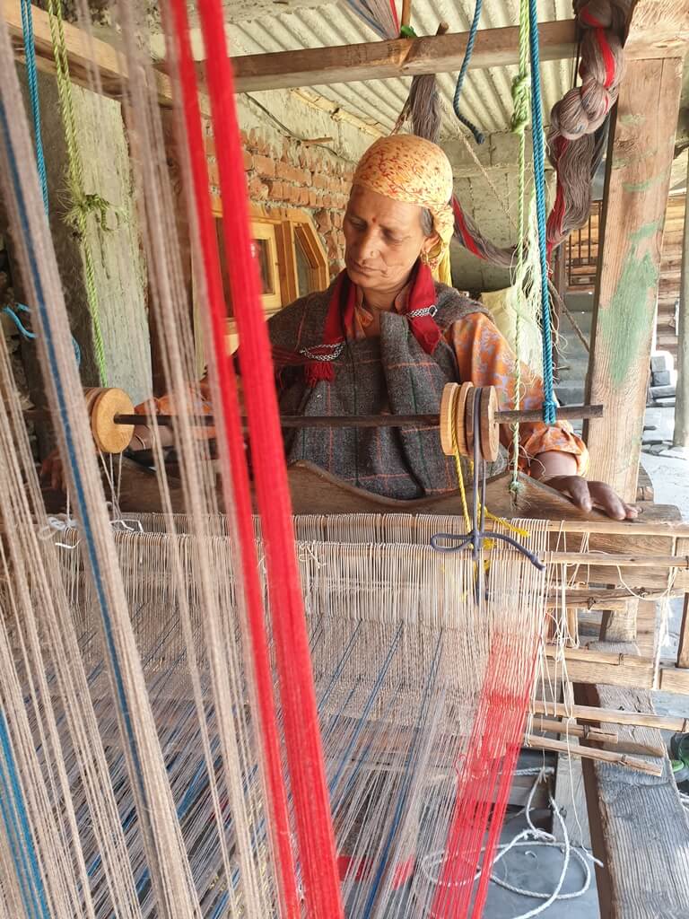 A local villager named Vimla weaving an authentic Himachali pattu on her handloom machine