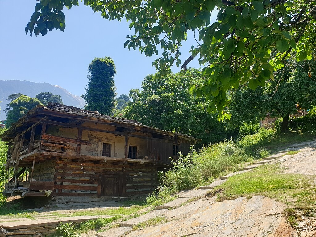 Primitive-style houses made from wood and stone can be seen in Rumsu village