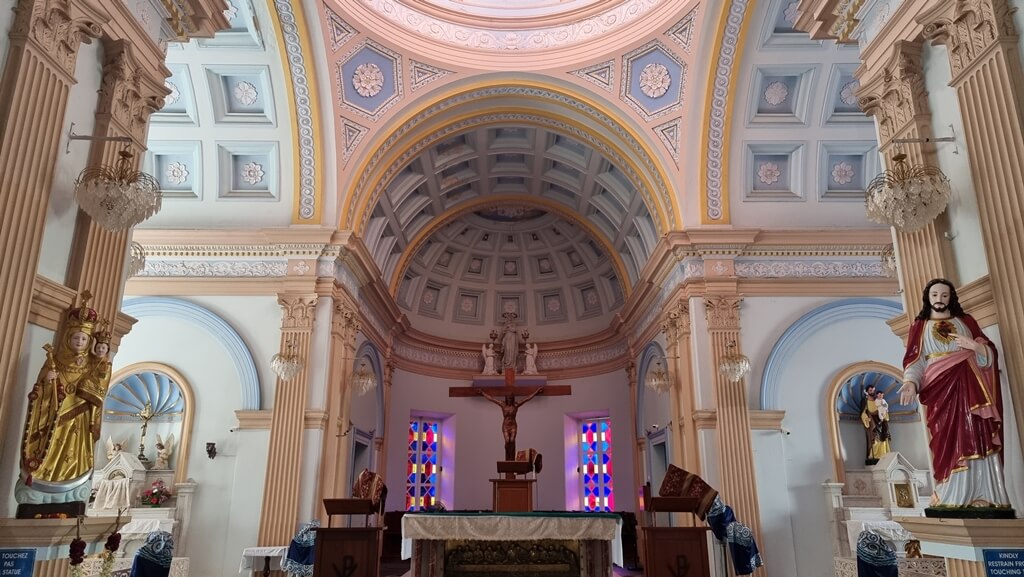 The church exhibits Greco-Roman style architecture with vaulted ceilings, arches, and stained glass windows