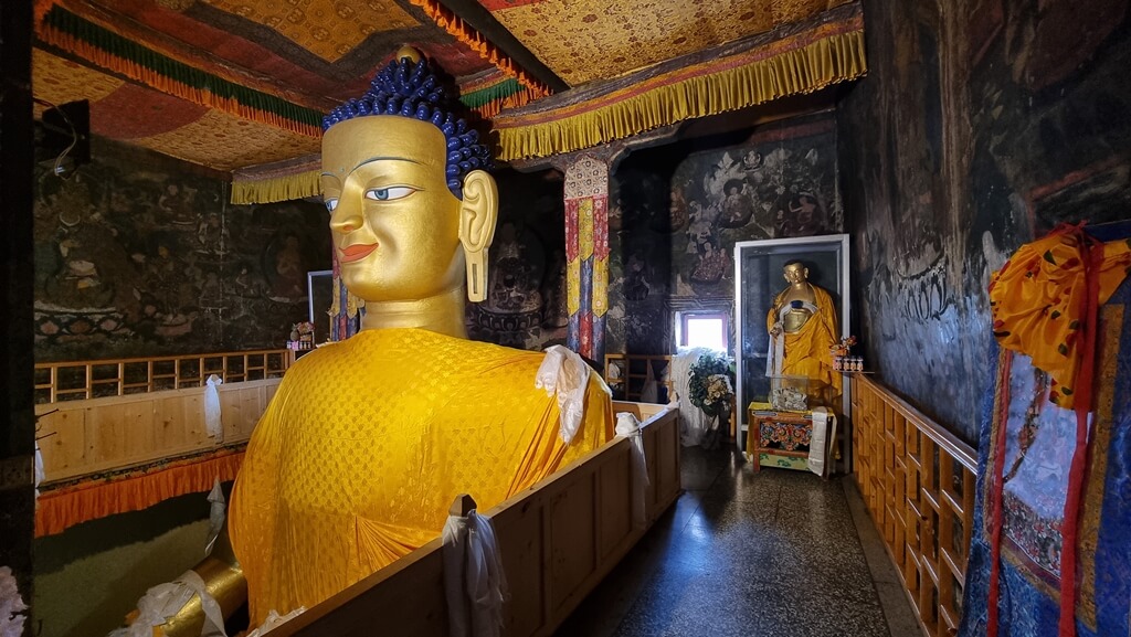 Meditating while sitting in front of the 40-feet statue of a seated Shakyamuni Buddha at the Shey Palace is one of the spiritual things to do in the 7-day Leh Ladakh itinerary