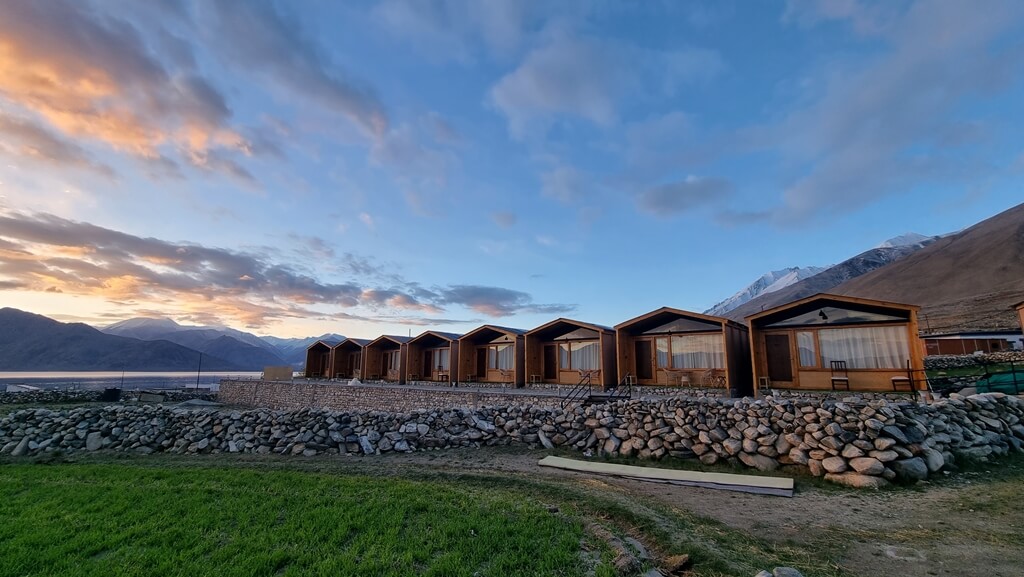 It has neatly built wooden cabins for you to stay and relax while in Pangong